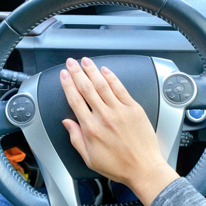 Hand on steering wheel, symbolizing license suspension consequences after a DWI - Law Office of Ira Z. Miller