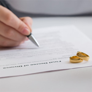 Final Divorce Decree Paperwork with Wedding Rings Symbolizing Separation